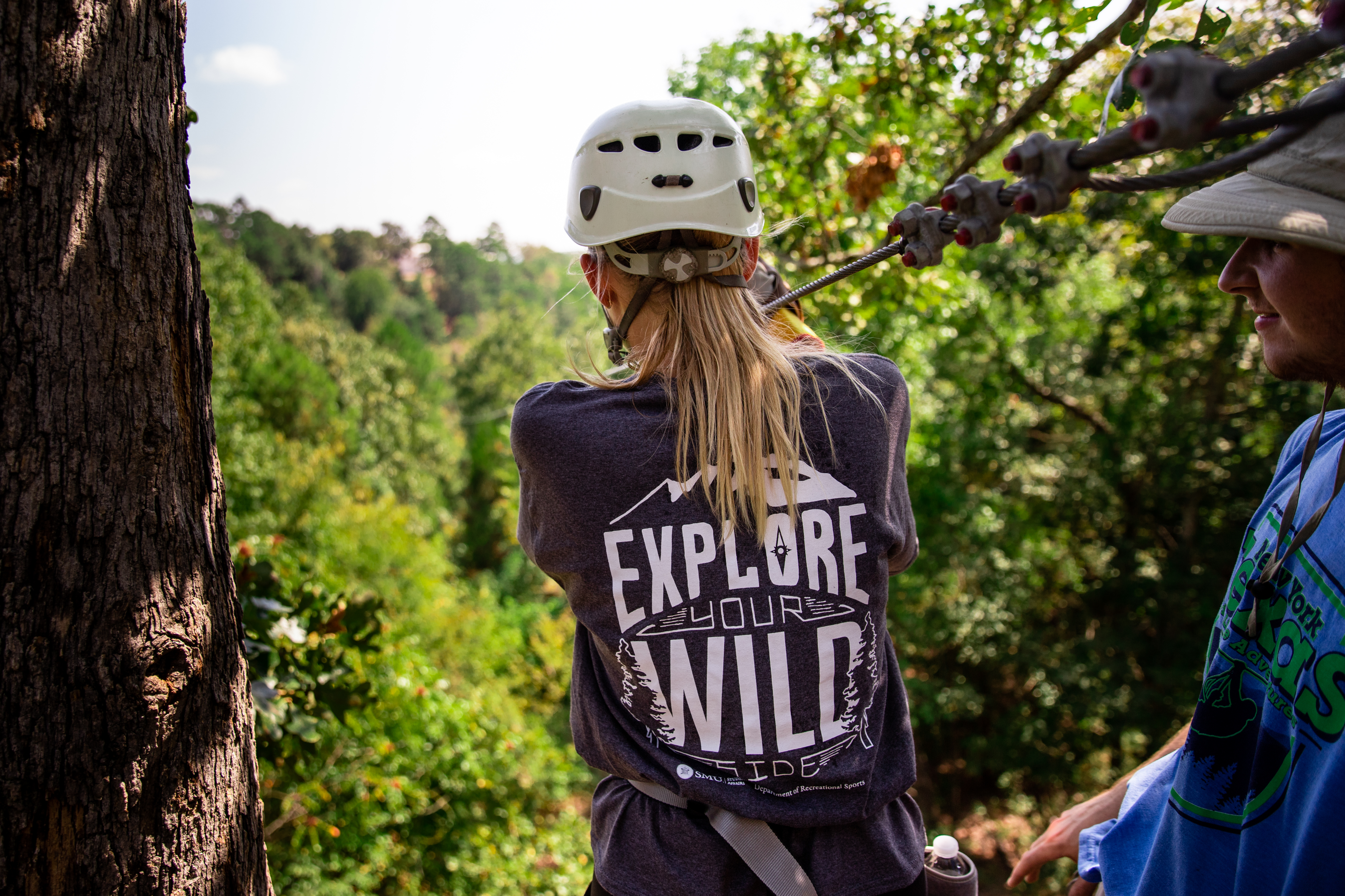 An image of a person preparing to zipline down the side of a mountain.