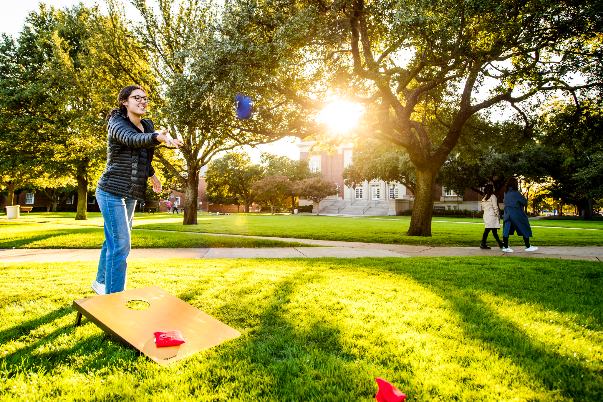 Student playing cornhole on Dallas Hall Lawn