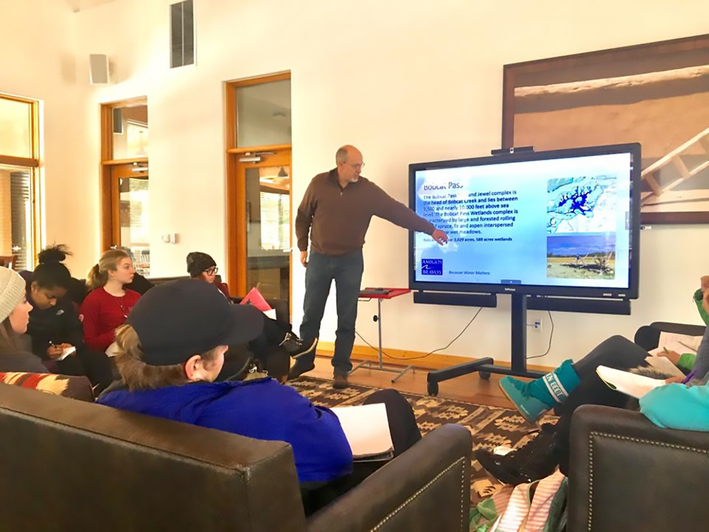 SMU-in-Taos faculty member teaches class inside a common area on campus