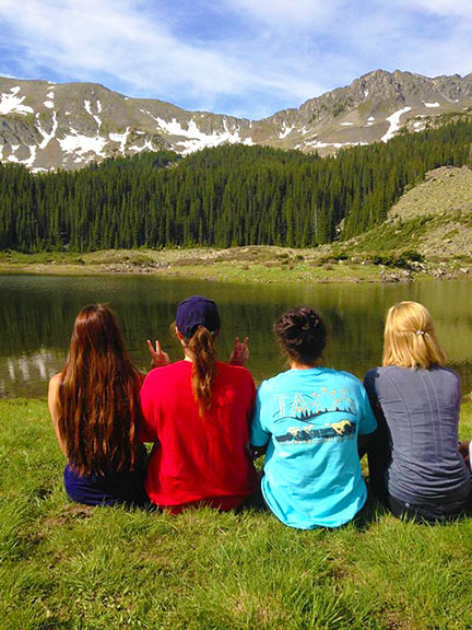 SMU-in-Taos students sit by a mountain lake