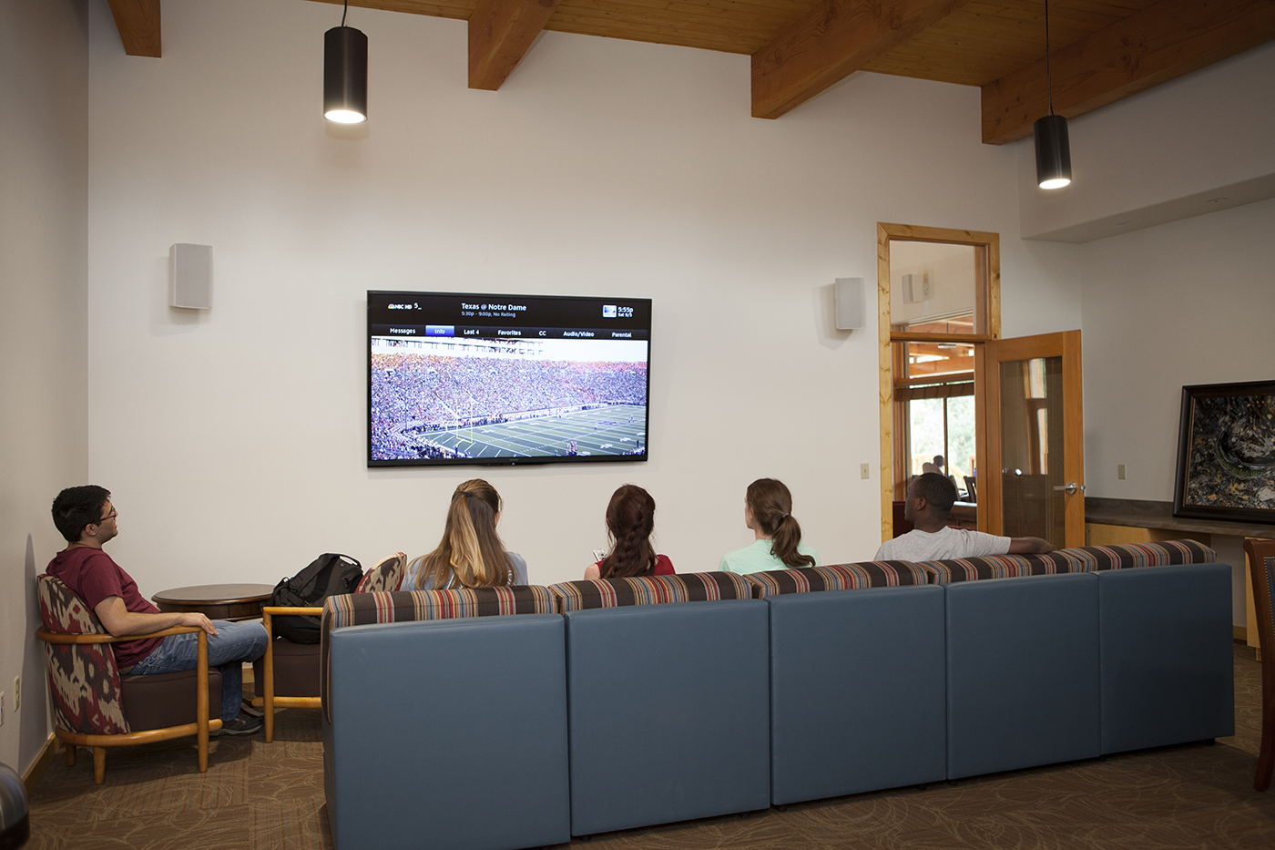 Students watch football in a common room inside the Miller Center at SMU-in-Taos