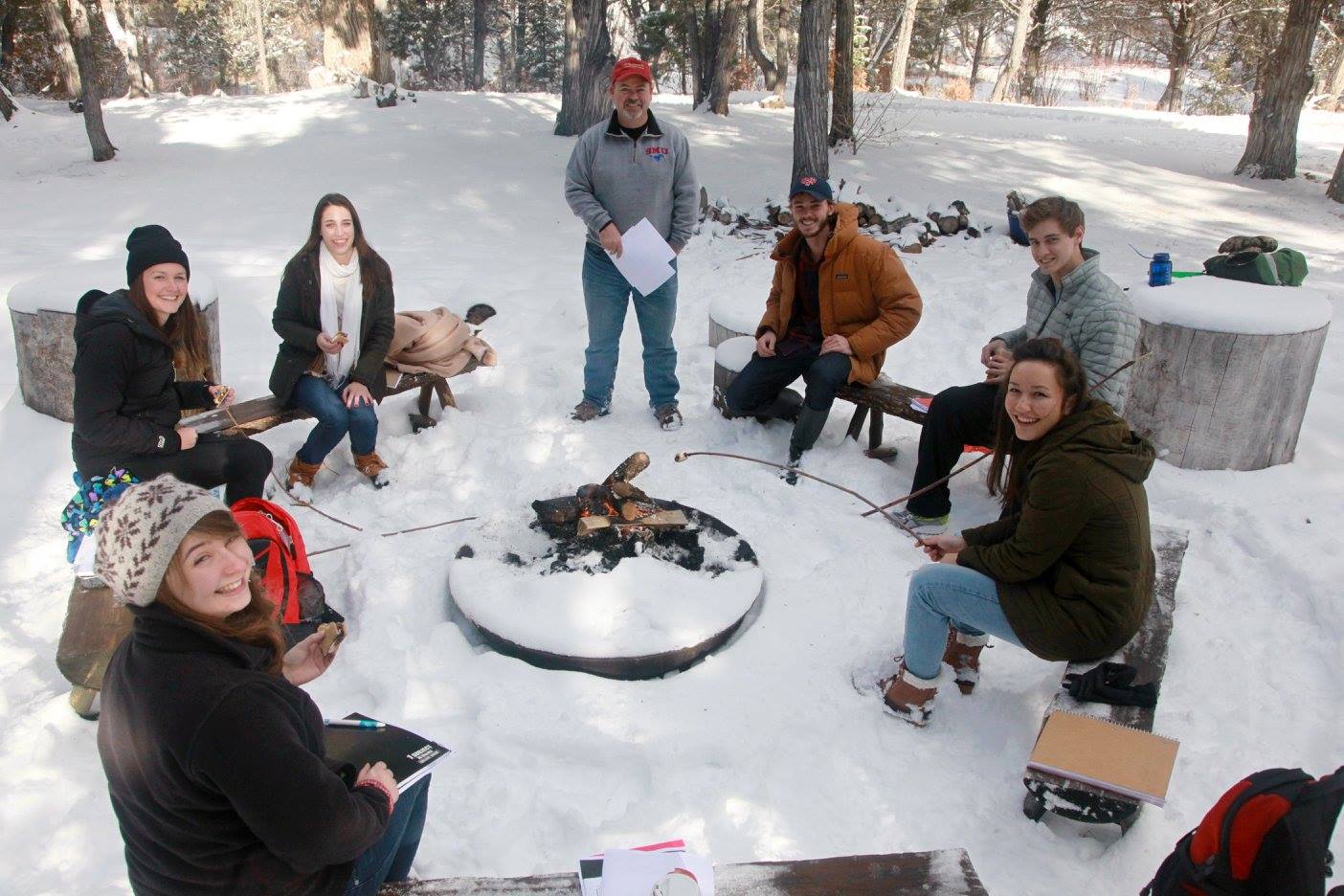 Students roast marshmallows over a campfire in the snow at SMU-in-Taos.