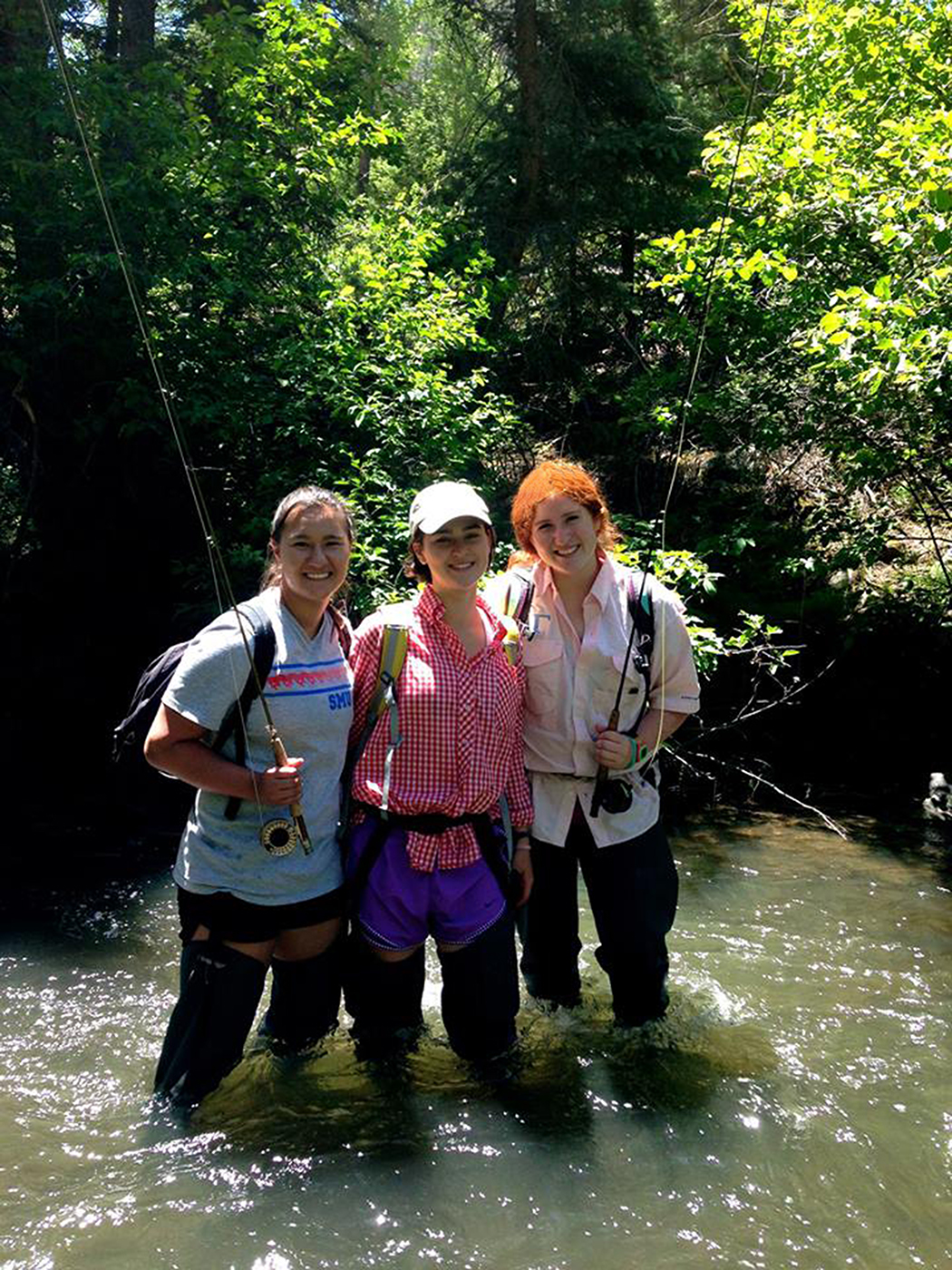 Three SMU-in-Taos student fly fishing in a river