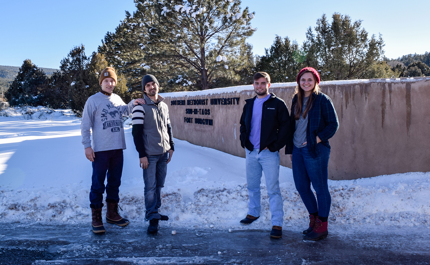 SMU-in-Taos students near the Fort Burgwin campus sign with snow on the ground