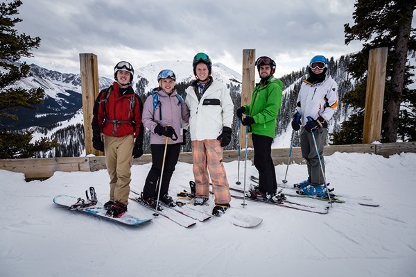 Five Taos students in full ski gear pose in the snow at the SMU-in-Taos campus.