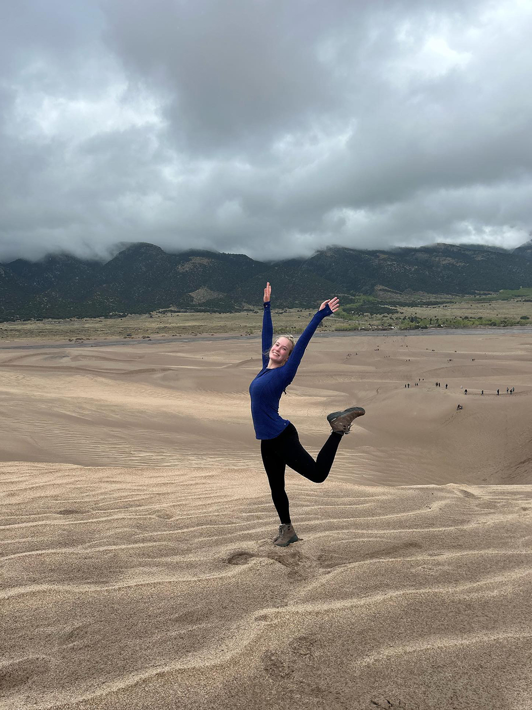 SMU-in-Taos student Ella Collard takes a moment to pose on the desert sand in Taos, New Mexico.