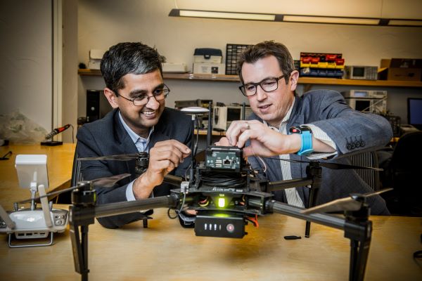 Dinesh Rajan and Joe Camp work on a drone