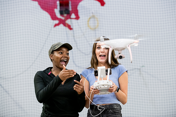 Image: Two students flying a drone with a camera