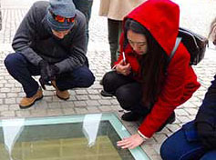 Meadows grad students Asiel Sepulveda and Claire Cho at the Bebelplatz in Berlin, examining Micha Ullman’s “Empty Library.”