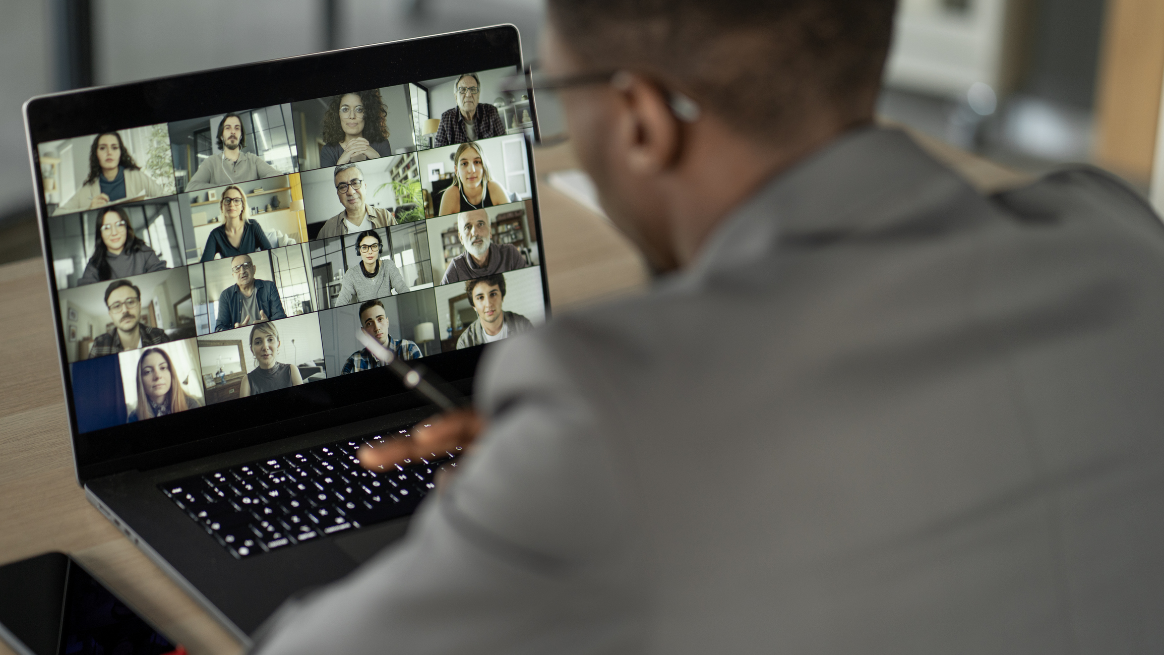 A stock photo of a man on a video conference with other people, wondering if it is secure