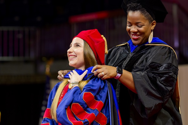 Female Professor hooding female PhD student at 2024 graduation