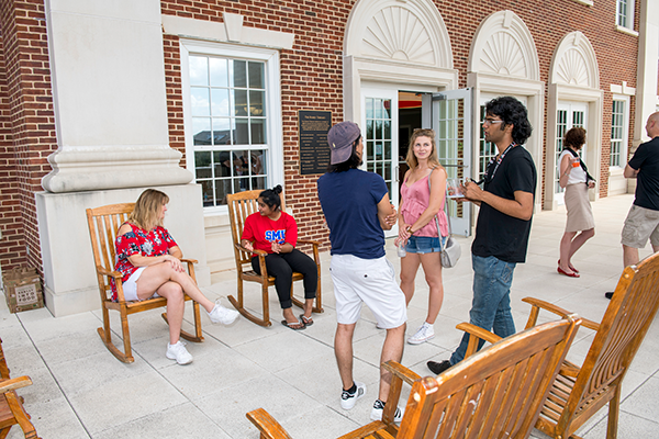SMU students talking with each other outside the SMU campus building.