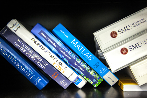 Stack of a SMU academic textbooks, representing research areas.