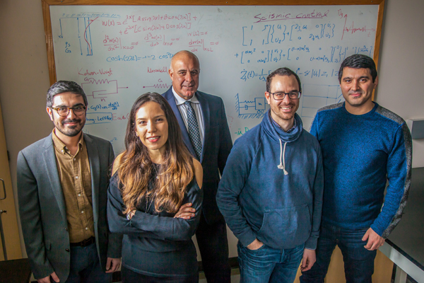 A group of five civil and environmental engineering researchers stand together in a lab.