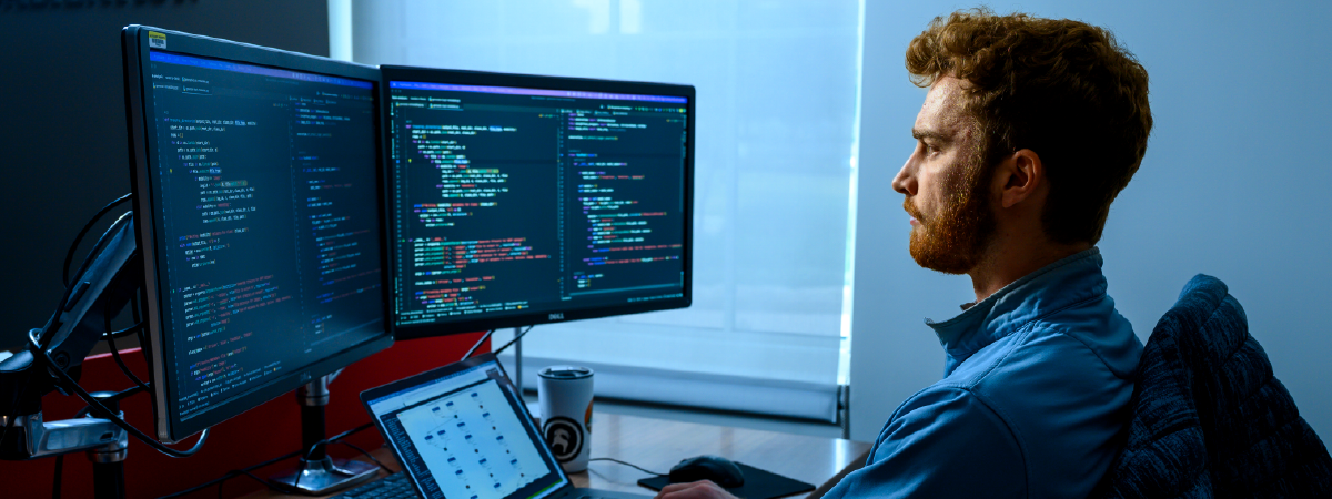 Student sitting at a computer writing code