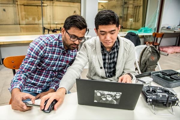 Two students work together on a computer at SMU Lyle.