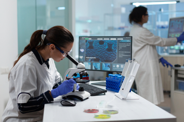 Adobe stock image of specialist biologist researcher analyzing biomedical virus sample using medical microscope working in pharmacology hospital laboratory.