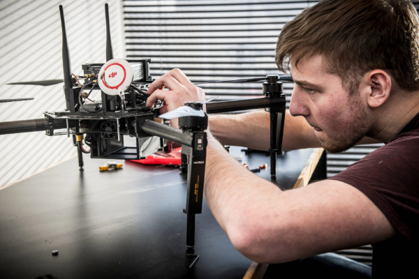 A student at SMU Lyle inspects a drone he is working on at the Electrical and Computer Engineering Department of SMU