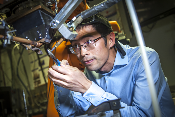 SMU Ph.D. student in mechanical engineering working with advanced robotic equipment in a research lab.