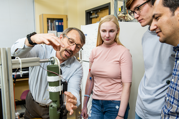 SMU professor demonstrating biomedical instrumentation to students in lab.
