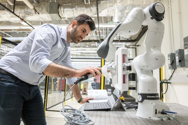 Soroush Korivand, a postdoctoral fellow at SMU, works with a robot in the Lyle School of Engineering’s new Center for Digital and Human Augmented Manufacturing on the SMU campus in Dallas.