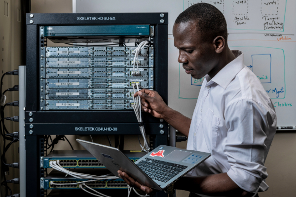 A student looks at his laptop studying Network Engineering
