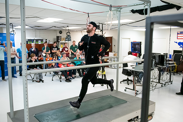Researcher testing walking mechanics using motion analysis equipment.