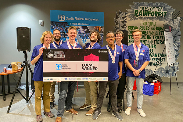 Smu students standing and holding a winner’s sign and medals.
