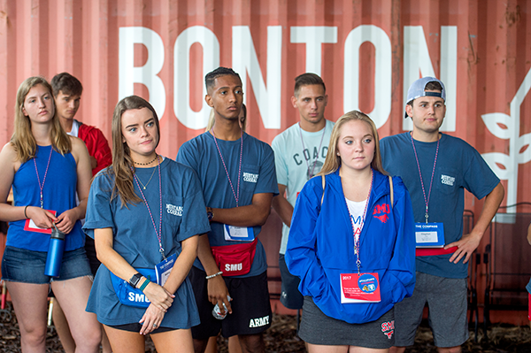 Group of SMU students wearing name badges standing together during a campus spotlight event.