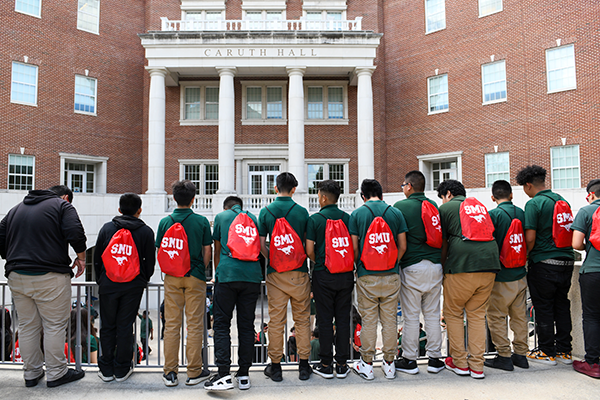 Group of SMU Lyle Students standing on there back, opposite to the caruth hall building