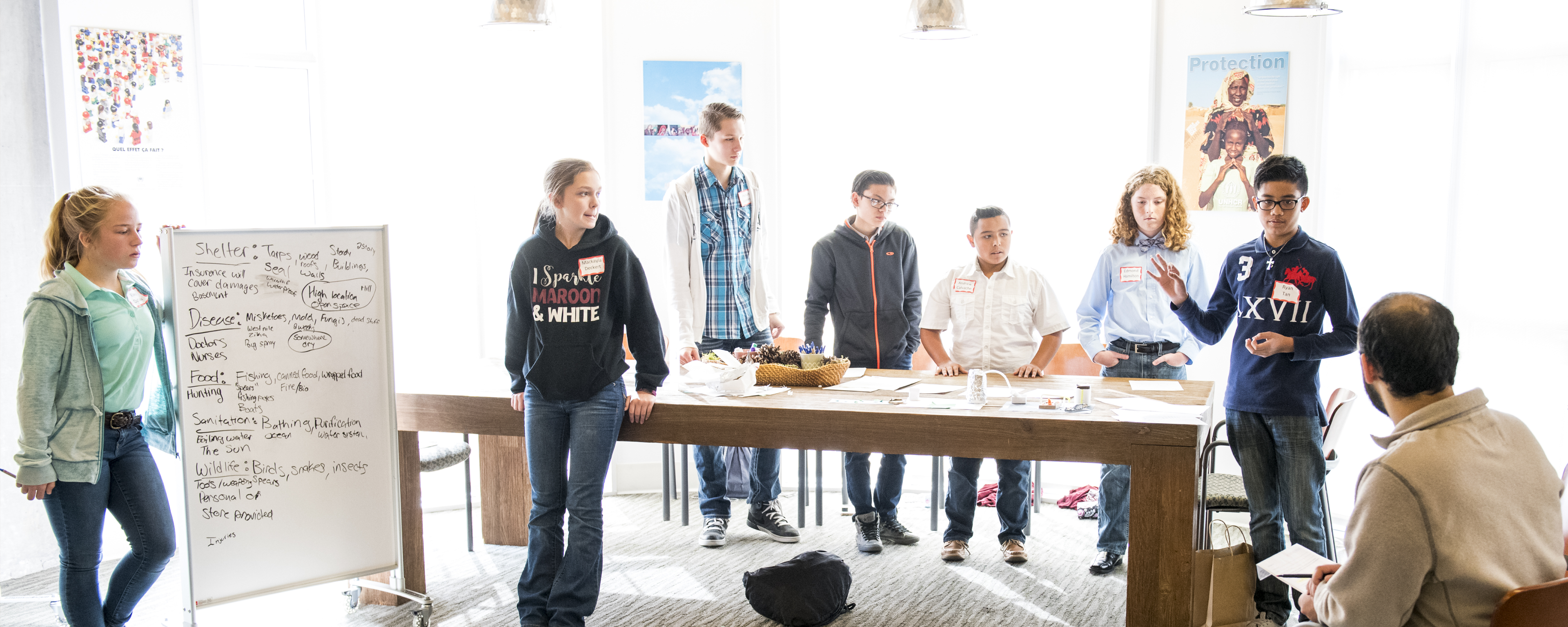 people in a room around a long table