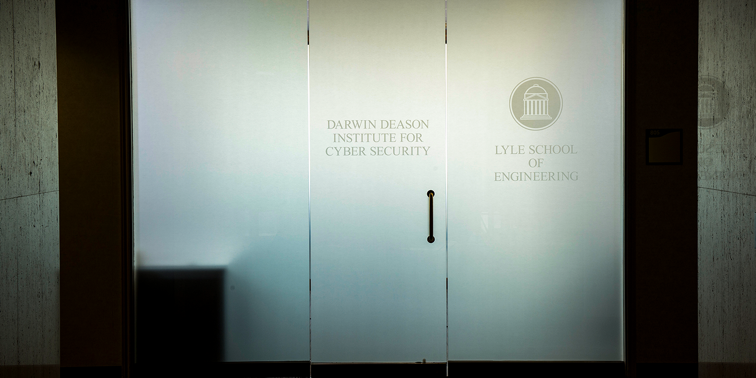 Image of young students working at a desk with iPad, laptop, and radio controller.