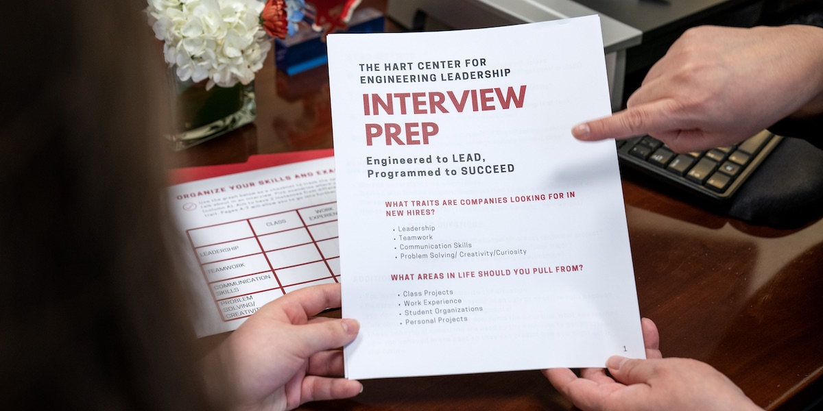 pointing to paper that says interview prep in red letters