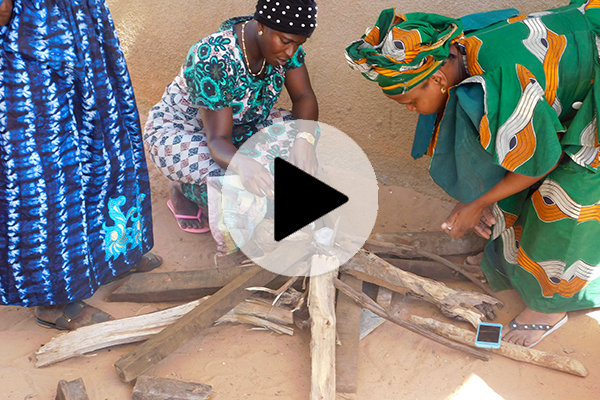 Founder Mohammed Nije with community members arranging firewood, representing Janta Energy