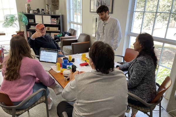 Graduate students sit around a table and discuss urban planning