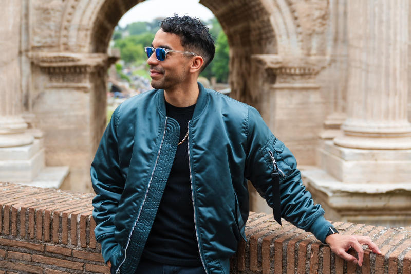 Lyle quantum engineering student and Quantum Falcon founder Angel Cuenca '27 poses outside with sunglasses on, leaning casually against a brick wall 