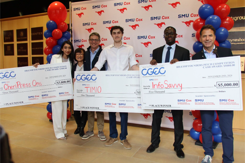 SMU students stand holding oversized checks after placing at the Hilltop Founders Pitch Competition