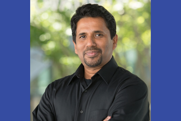 A portrait of Dr. Mahesh Krishnamurthy with a blue background