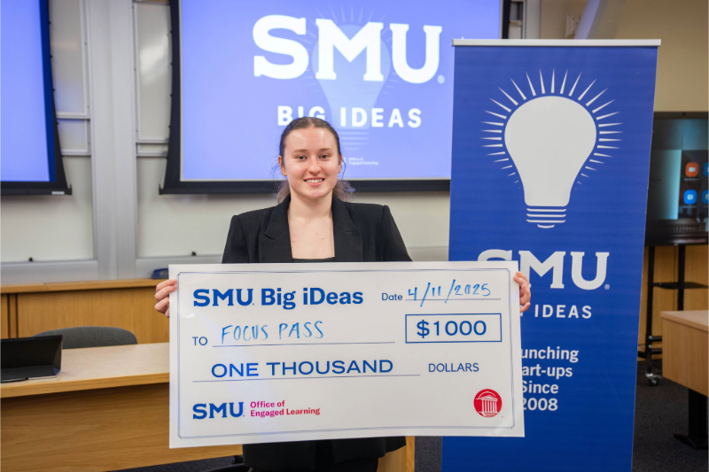 Sophia Vasylyeva holds up a large check for $1000 at the SMU Big iDeas competition in 2026