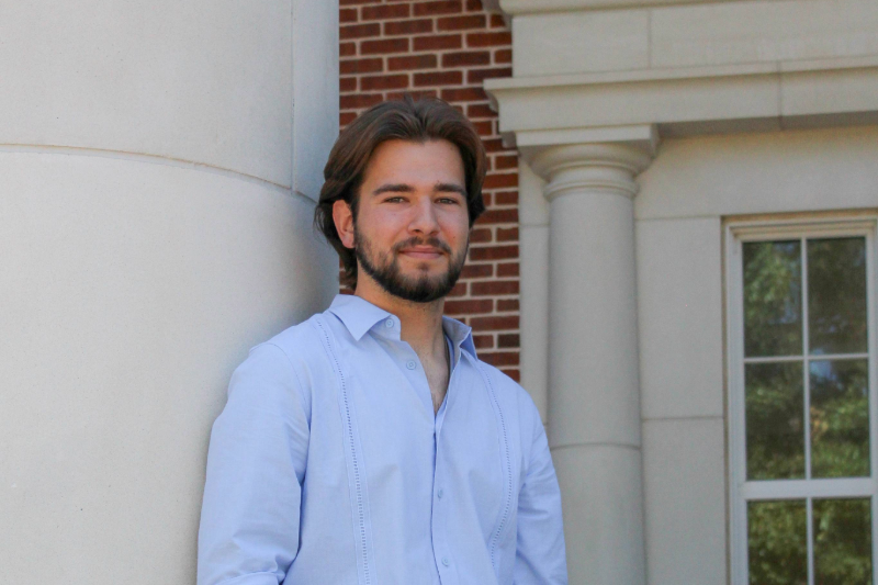 A portrait of SMU Lyle student Michael Llanes outside the Caruth building at SMU in Dallas, Texas