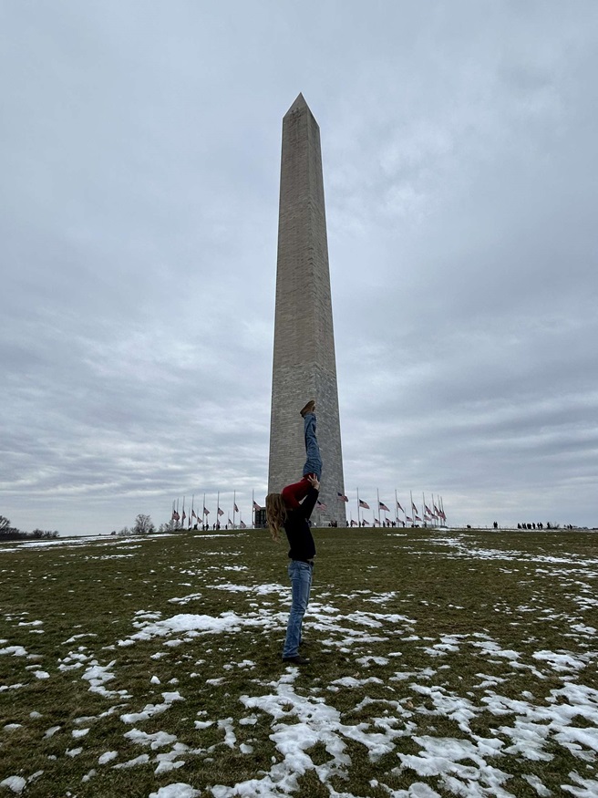 A photo of Michael Llanes lifting another student up in the air in Mustang Mavs fashion in front of the Washington Monument