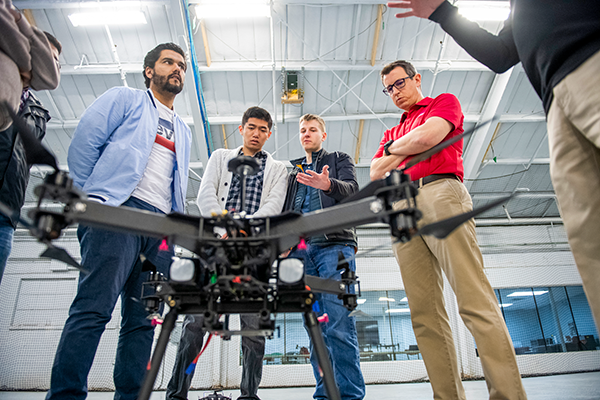 Students gather around a drone 