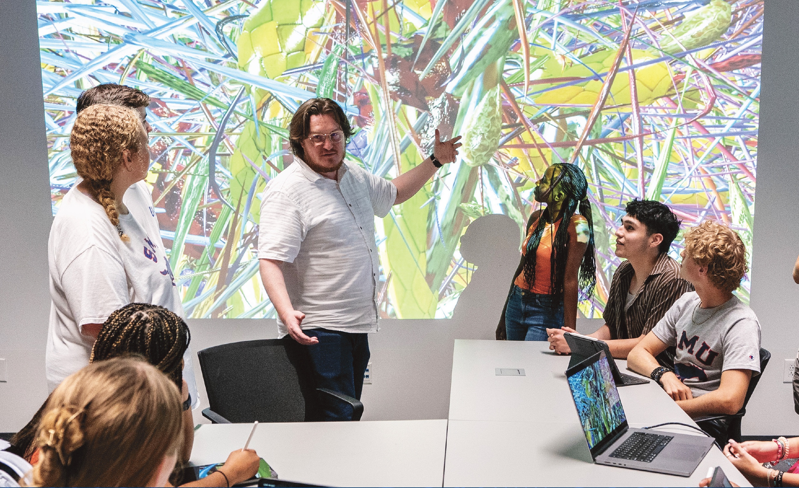 People working in a room with a large screen