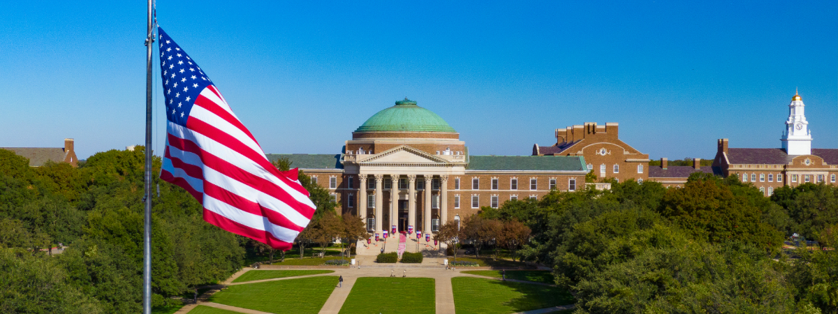 A view of Dallas Hall at SMU with an American flag