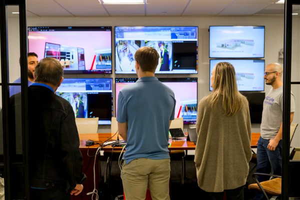 Three people standing opposite to the computer
