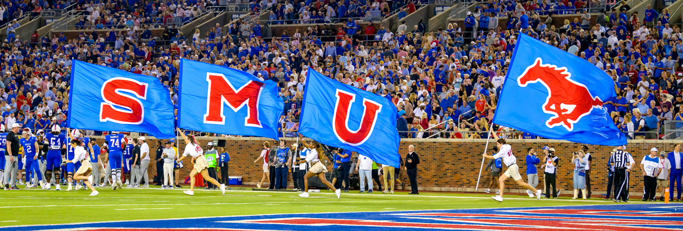 SMU students running across the field with the SMU flags after a touchdown