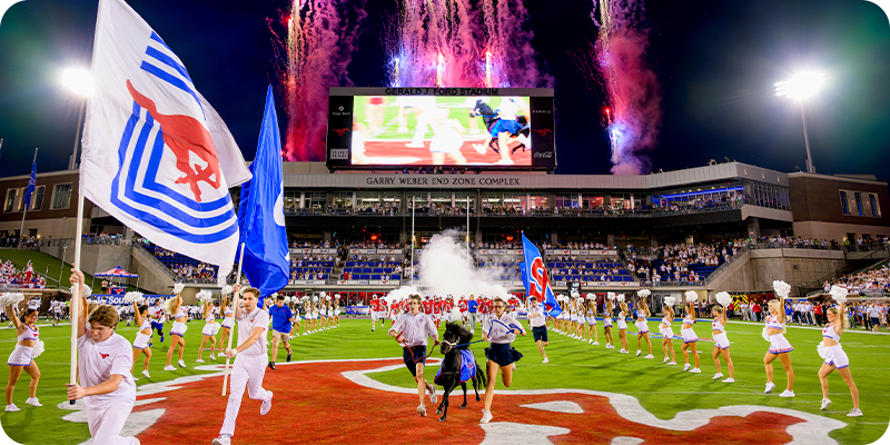Peruna running down the field with the handlers to begin the game