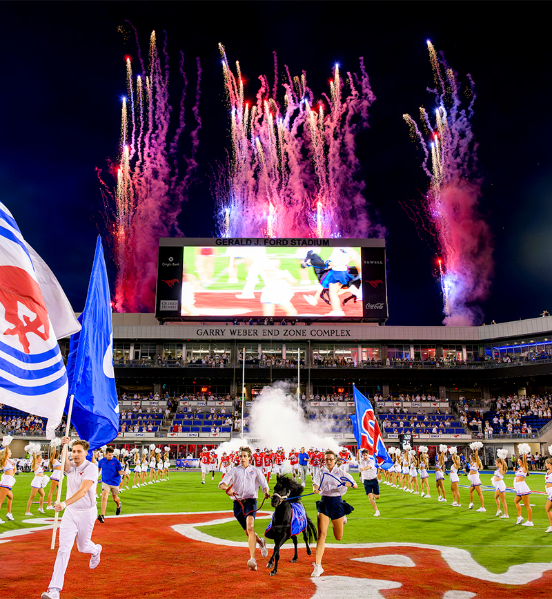 Peruna running down the field with the handlers to begin the game.