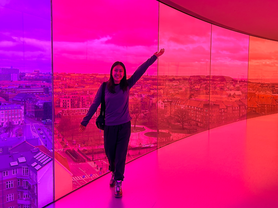 Student poses in front of a city scape