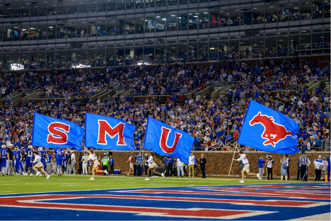 Students running across Ford Field during SMU home football game